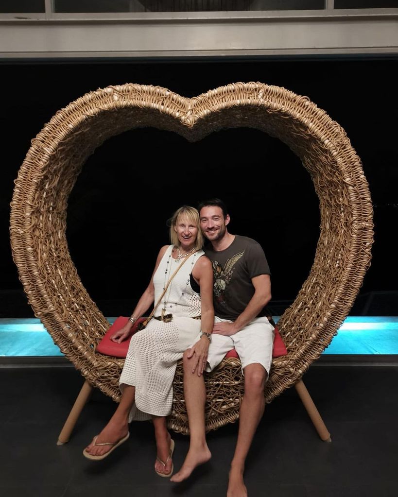 Carol McGiffin posing in a heart seat with her husband Mark