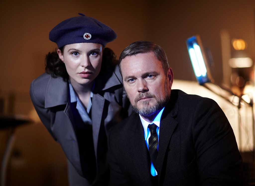 woman in uniform next to man in suit 