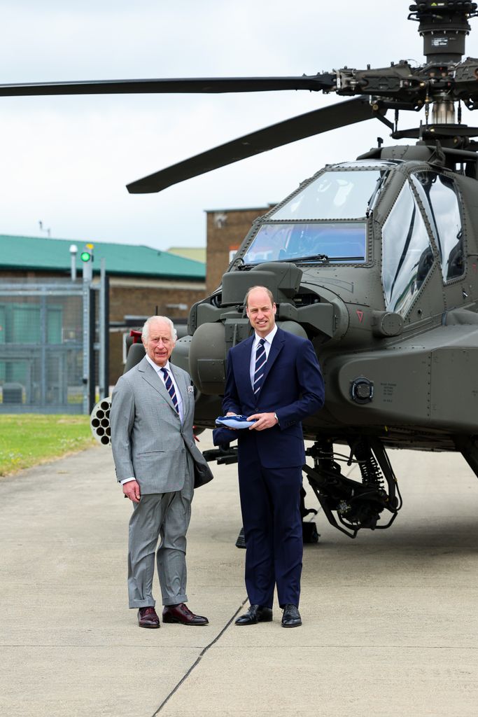 Charles and William posing in front of a helicopter