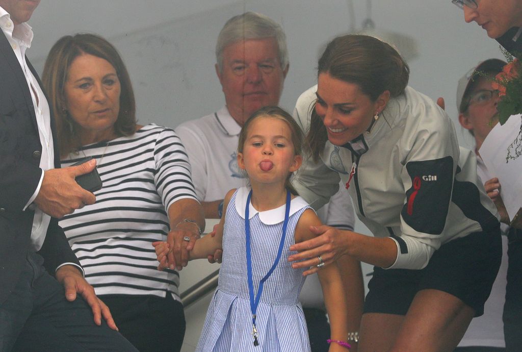 Kate with Princess Charlotte and Carole Middleton look through a window at the prize giving after the King's Cup regatta at Cowes on the Isle of Wight