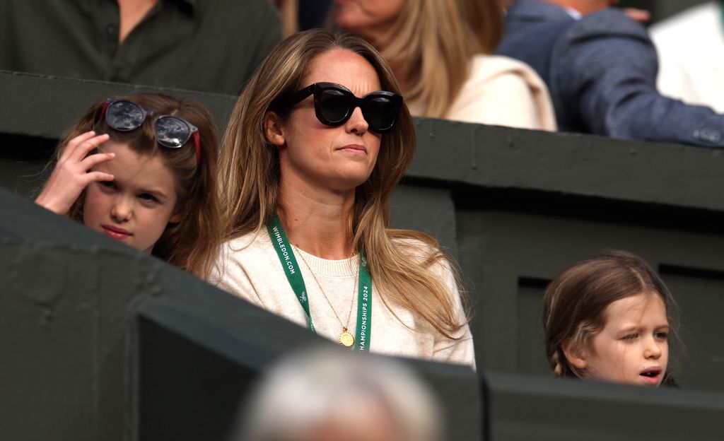 Kim Murray with two young girls watching tennis