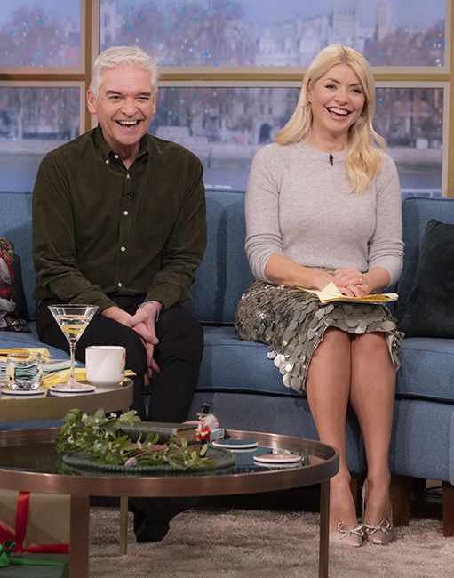 holly and phillip laugh as they sit on this morning sofa