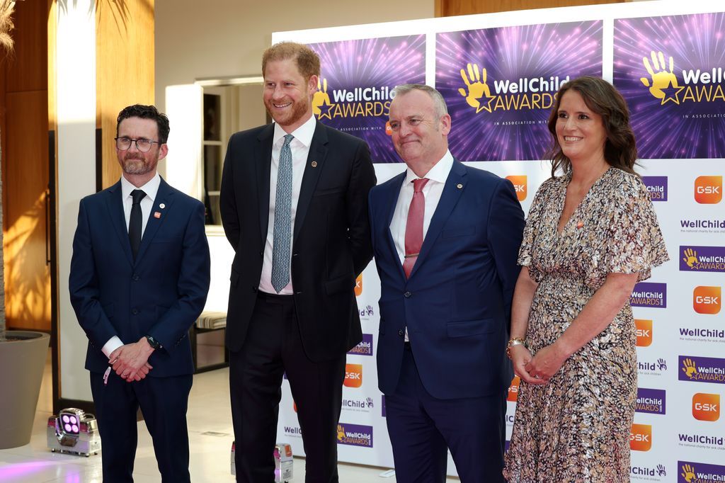 Prince Harry stood with two men and a woman