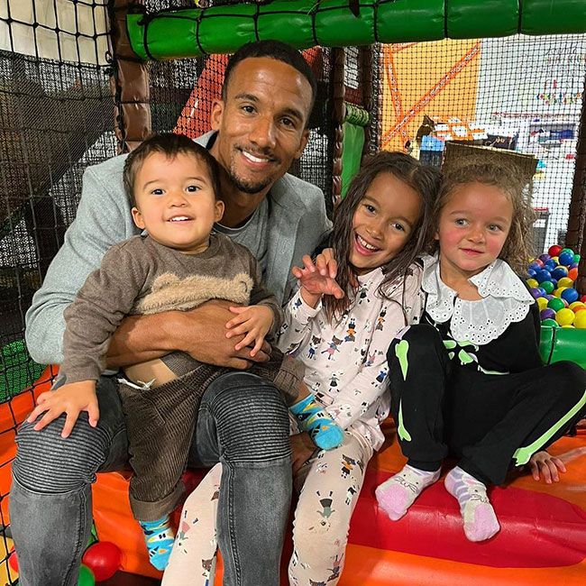 Scott Sinclair posing with his three kids in a soft play area