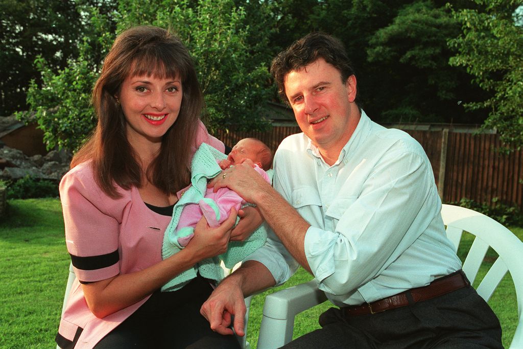 Carol Vorderman holds baby Katie next to her second husband Patrick King sat in the garden
