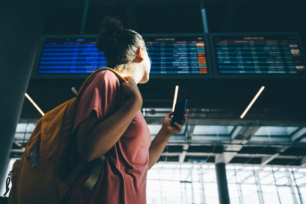 Woman checks airline schedule at airport.