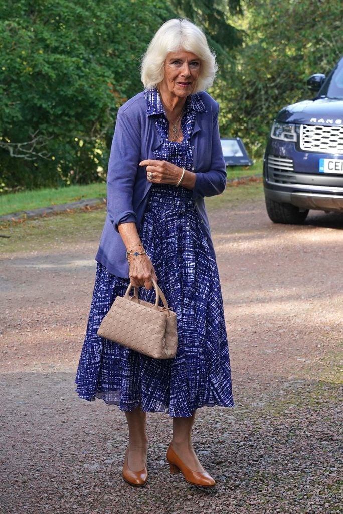 Queen Camilla walking to the church entrance wearing a blue dress and cardigan
