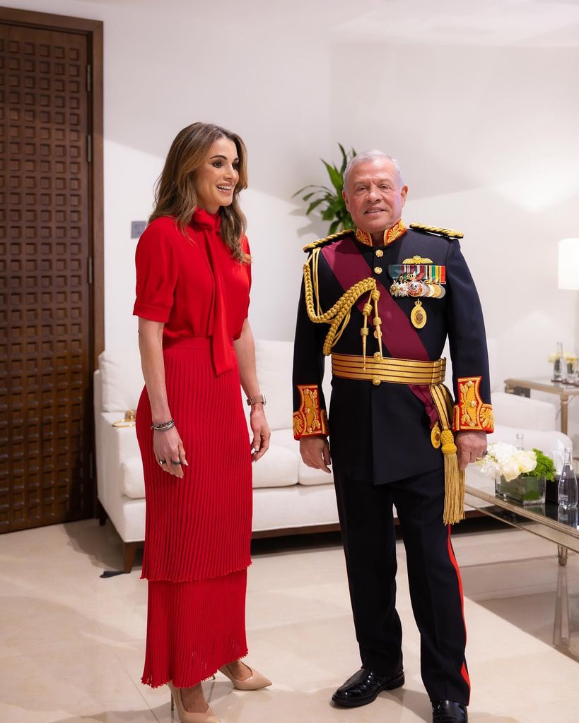 Queen rania in red with kign abdullah