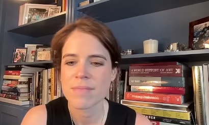 Eugenie in from her home office with book shelves behind her