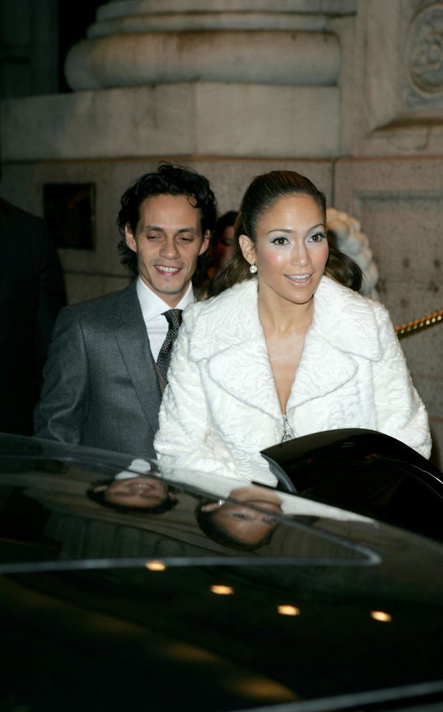 Marc Anthony in gray suit and Jennifer Lopez in white coat photographed in 2004