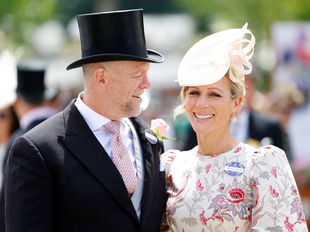 Mike Tindall in a suit and top hat looking at Zara Tindall in a floral dress