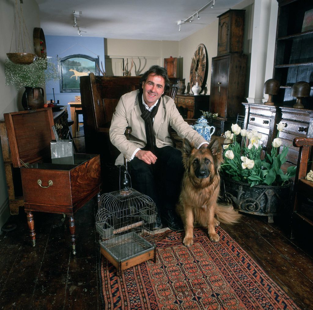 Paul Martin is surrounded by antique furniture