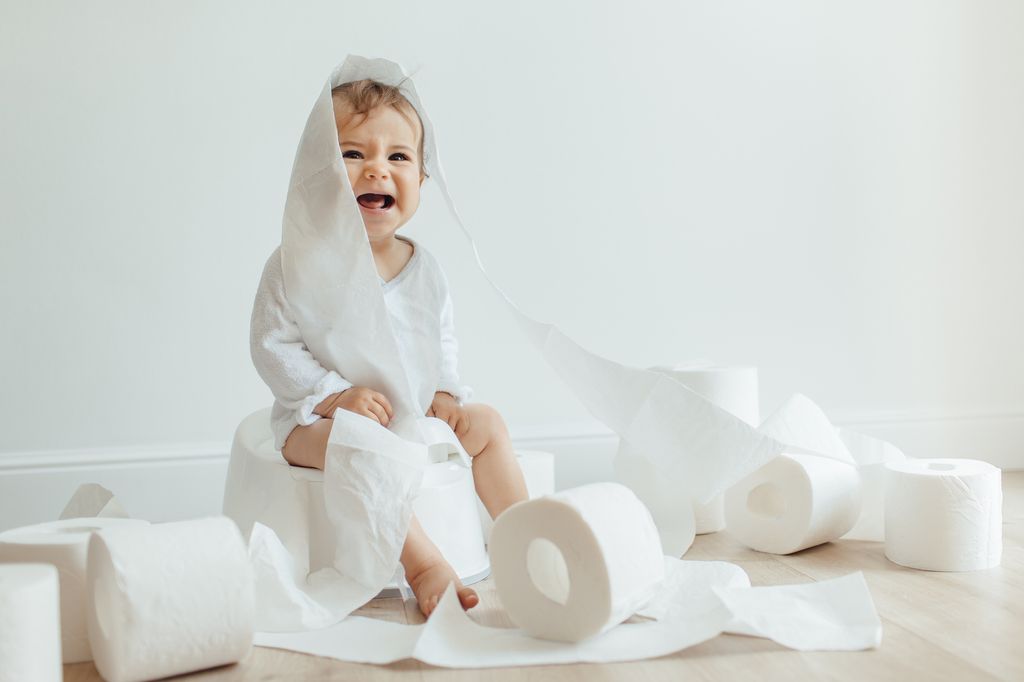 toddler with toilet roll on head and all around 