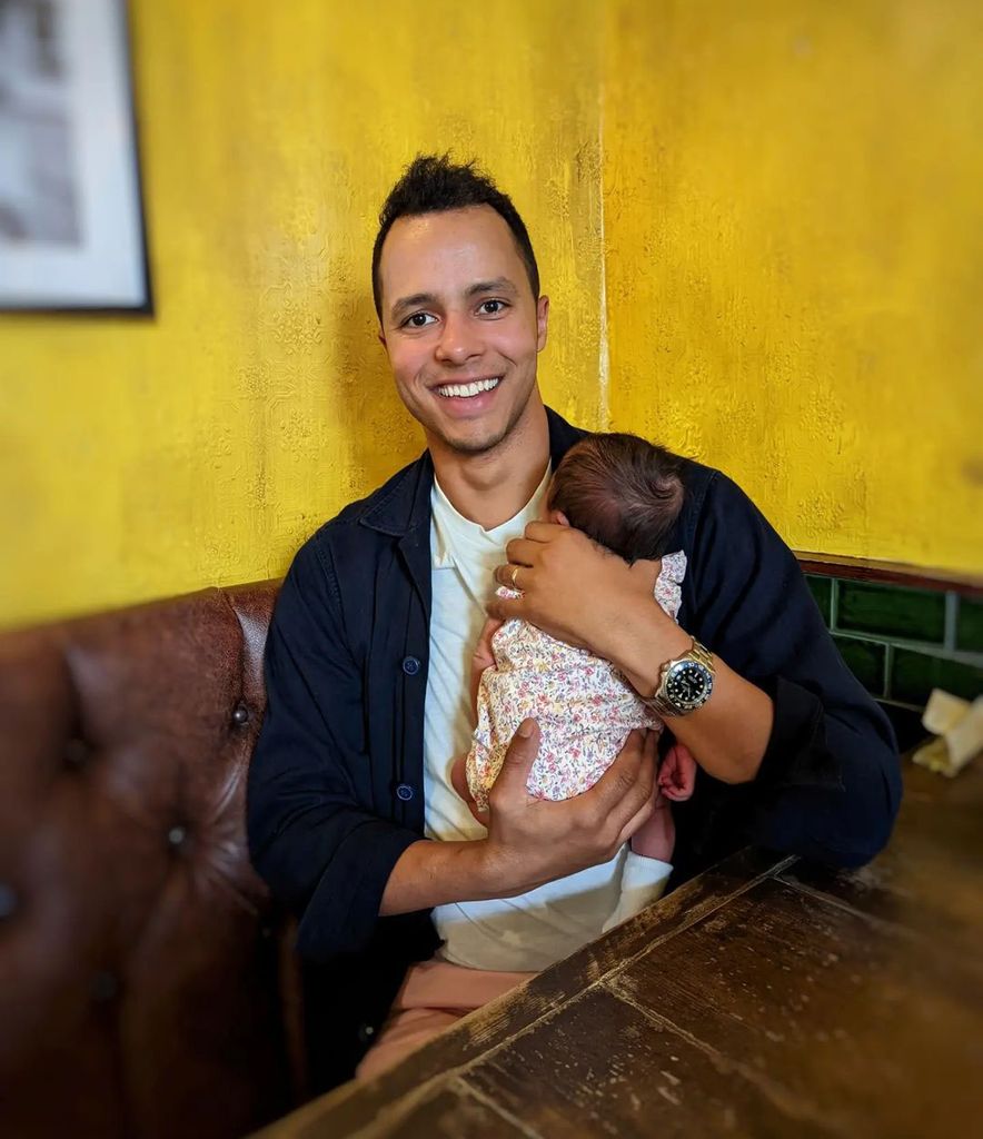 will kirk from the repair shop holding baby daughter wearing floral babygro