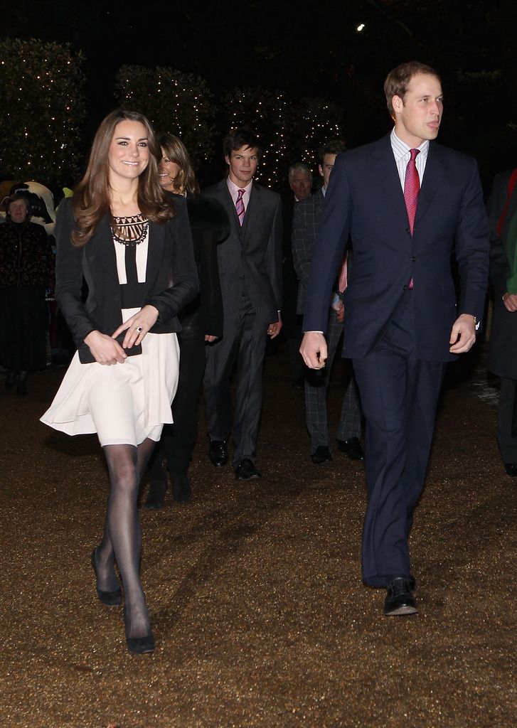 Prince William in suit and kate in white dress walking