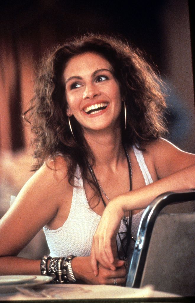 Julia Roberts smiling wearing the iconic white and blue dress in Pretty Woman 