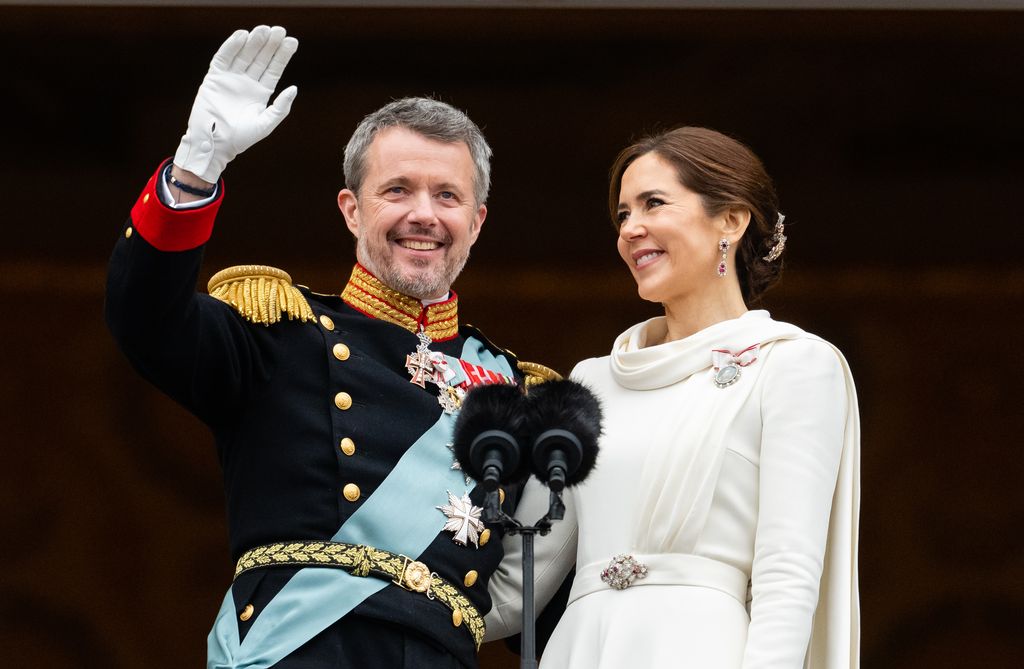 King Frederik waves from balcony with Queen Mary