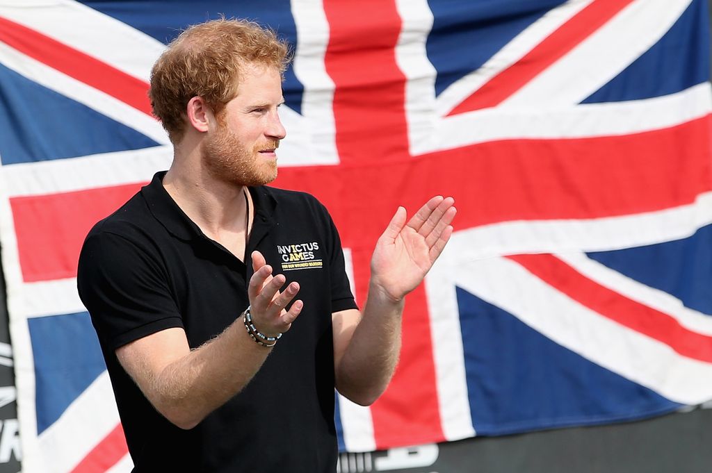 Prince Harry standing in front of a Union Jack