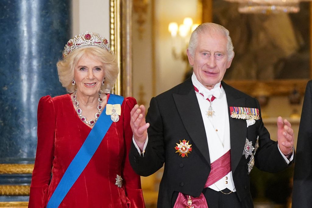 Queen Camilla wearing red dress and ruby jewels
