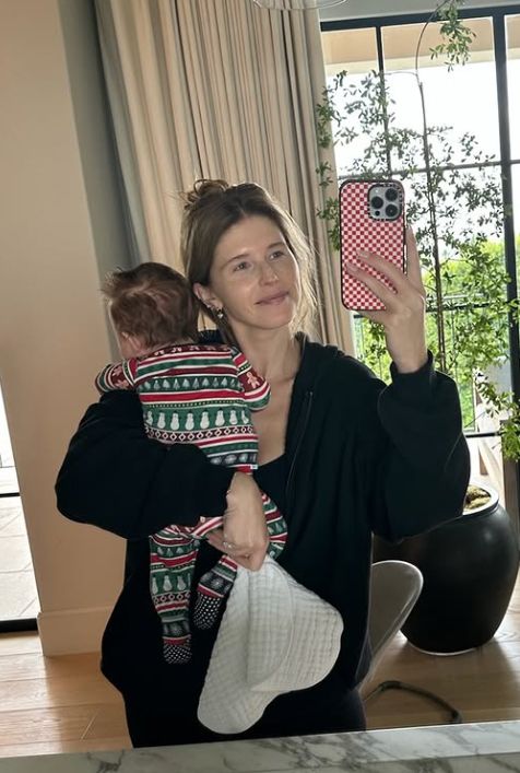 Katherine Schwarzenegger holding a baby with a balcony behind her