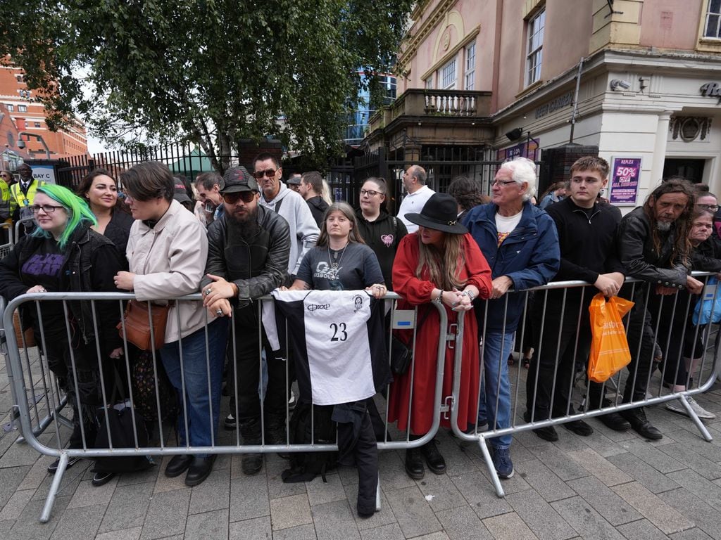 BIRMINGHAM, UNITED KINGDOM - JULY 30: People wait on the Black Sabbath Bridge bench in Birmingham, United Kingdom on July 30, 2025, ahead of the funeral procession of Ozzy Osbourne, the legendary British heavy metal musician and frontman of Black Sabbath, who passed away at the age of 76. (Photo by Ioannis Alexopoulos/Anadolu via Getty Images)