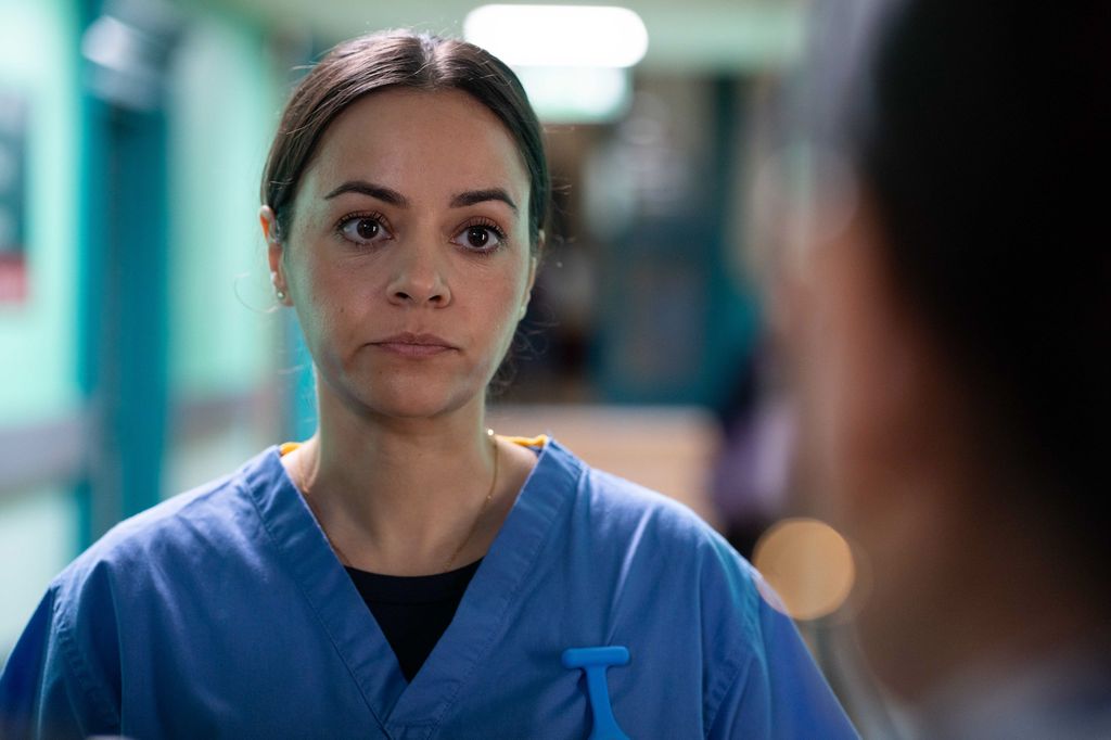 Woman in nurses uniform looking past camera