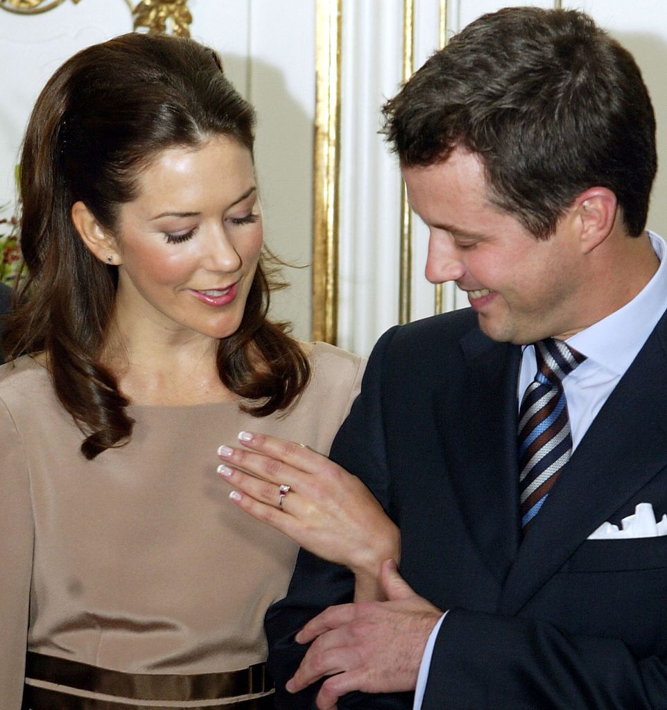 Crown Princess Mary in a cream top holding up her left hand to show off her engagement ring in 2003