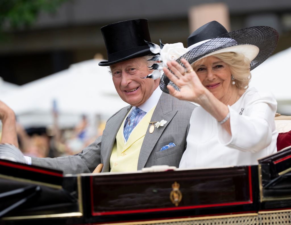 King Charles and Queen Camilla riding in a carriage