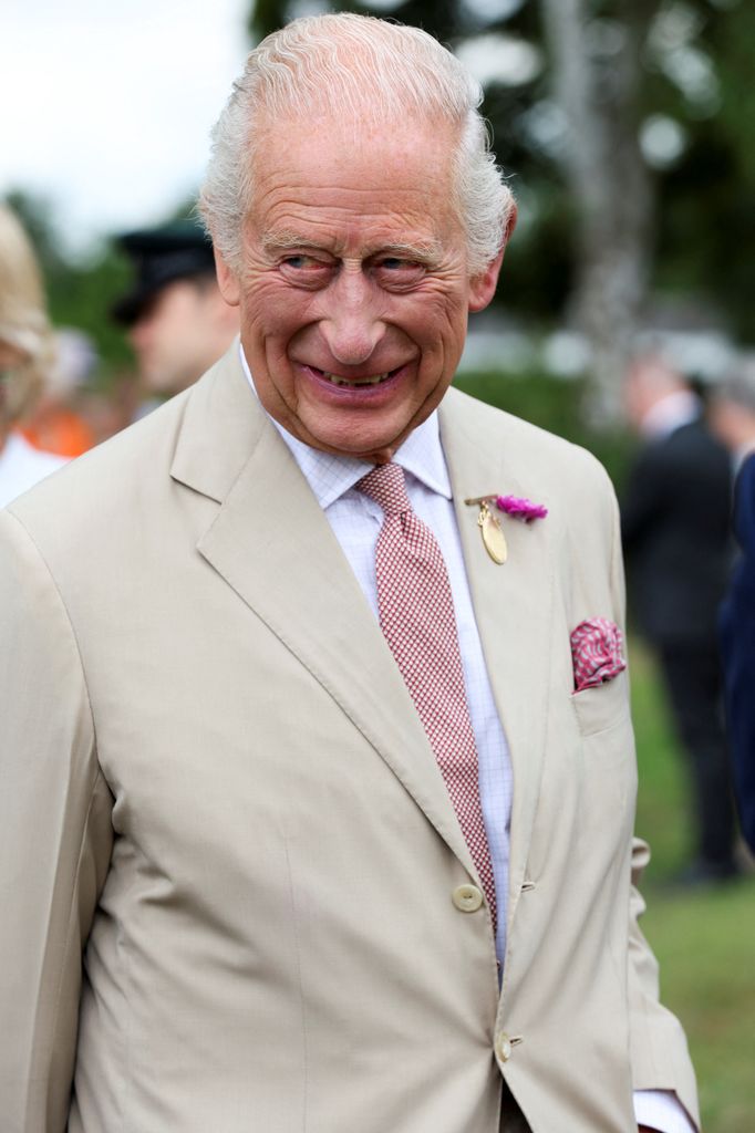 King Charles III smiles and reacts to visiting horses at The National Stud 