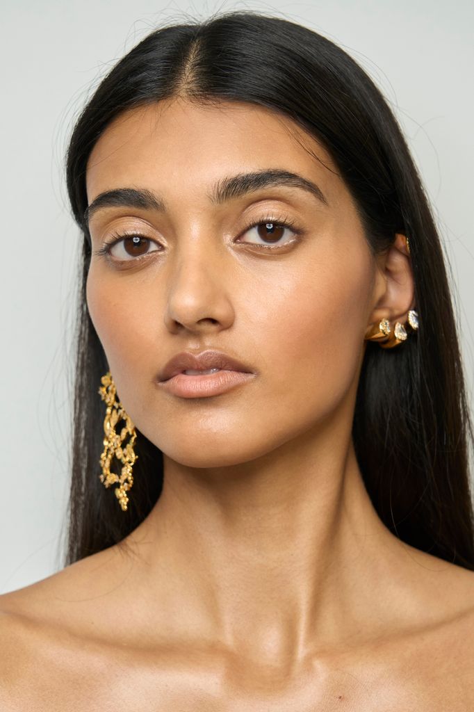 A model poses back stage in a sleek makeup look at the Zimmermann S24 show