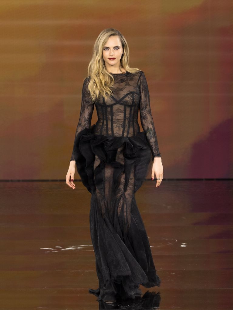 Cara Delevingne in black lace dress walking on runway