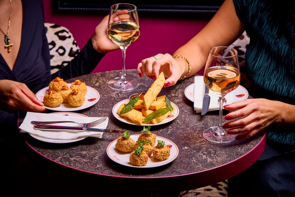 People eating small plates and drinking wine