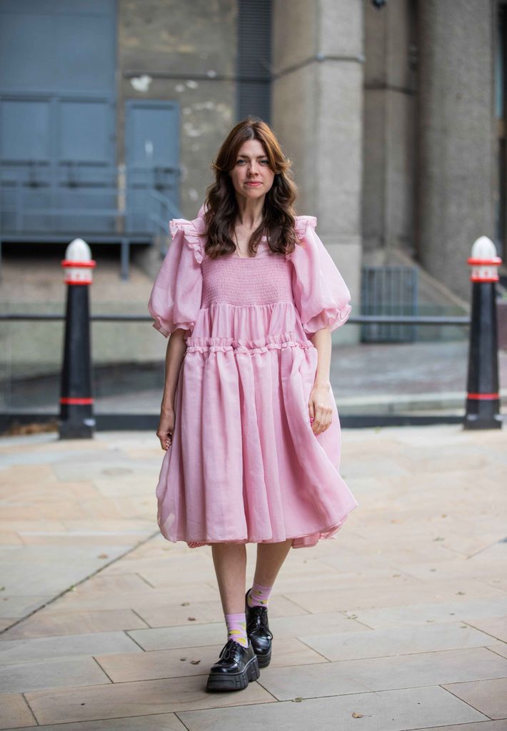 A guest wearing a pink smock dress