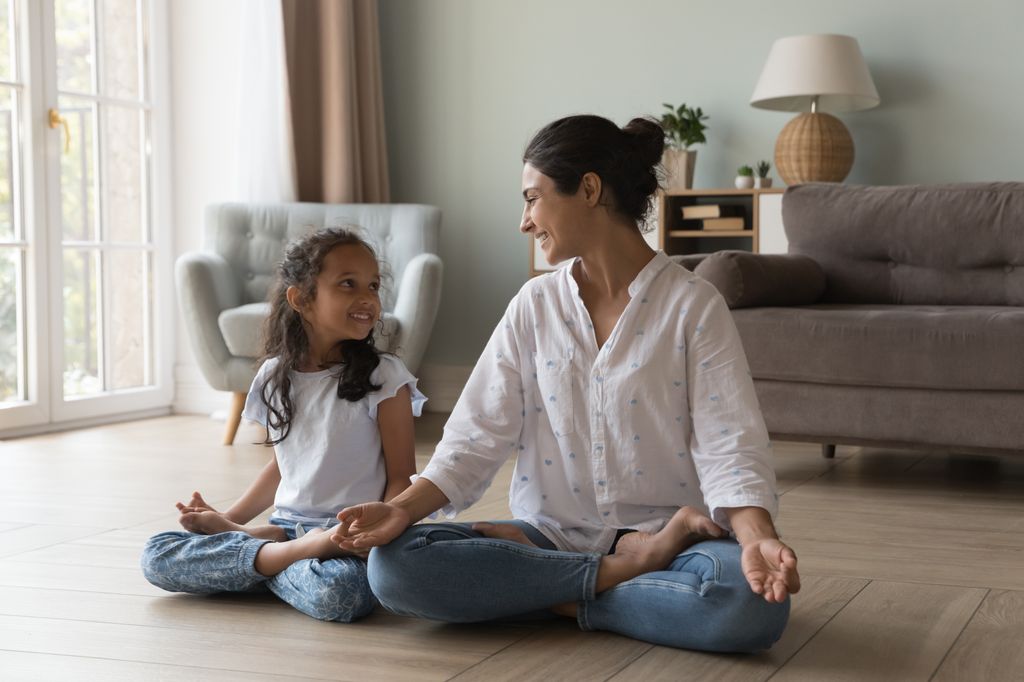 woman and young girl doing yoga at home