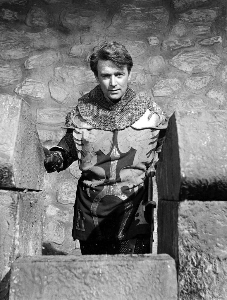 Black and white photo of man wearing suit of armour 