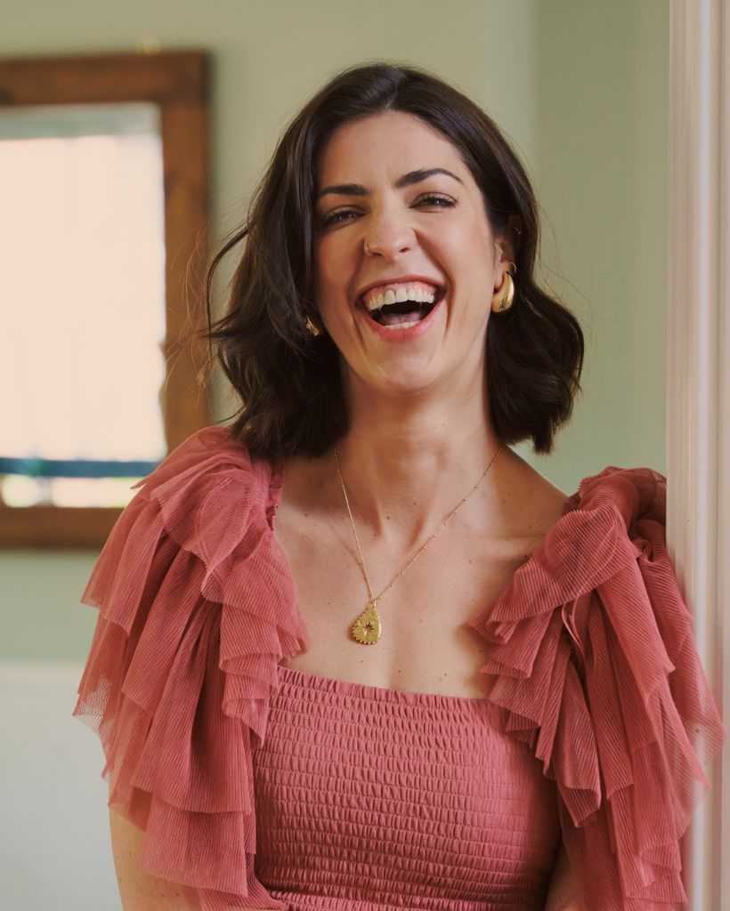 woman laughing in a frilly sleeved top 