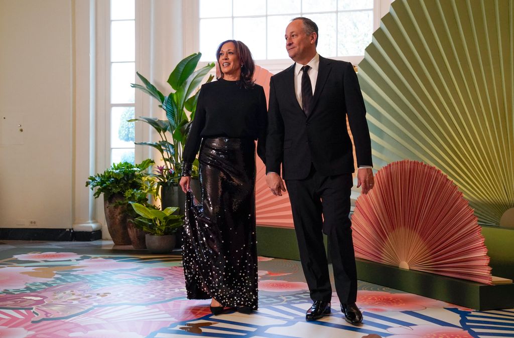 Kamala Harris in a sparkly skirt holding hands with Doug