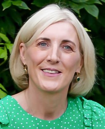 headshot of a woman in a green top smiling 