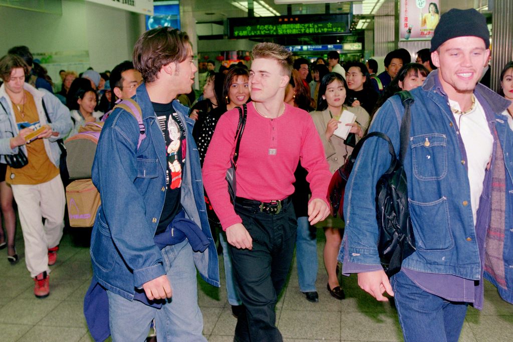Robbie and Gary walking through airport in 1990s