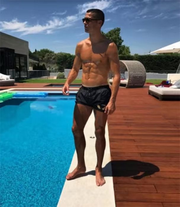 cristiano ronaldo in trunks stood next to swimming pool