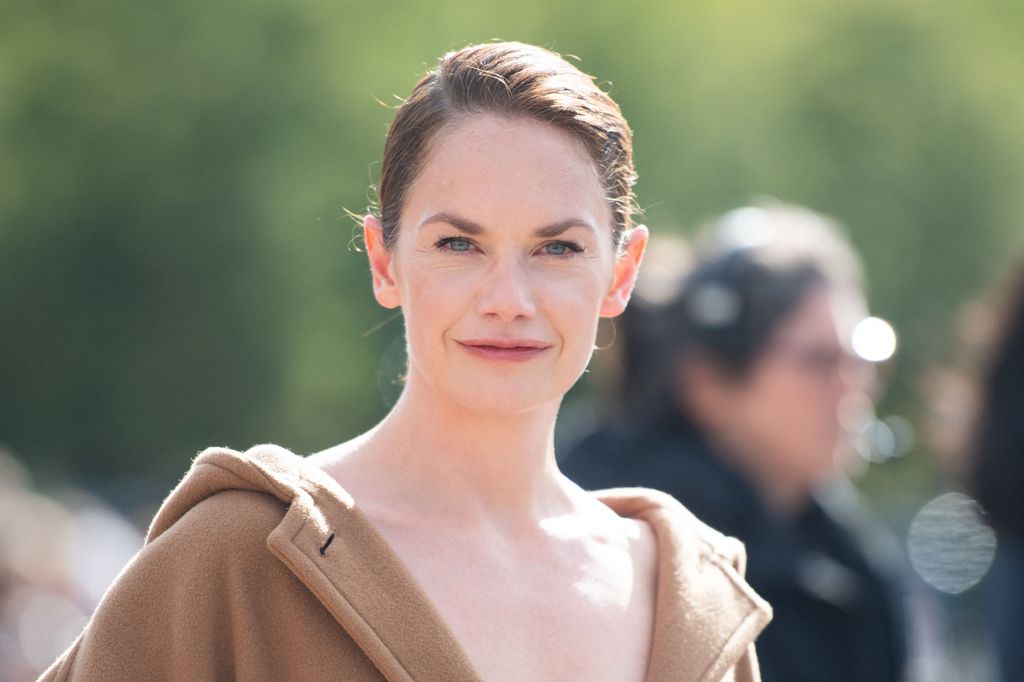 femme brune souriant pour la photo