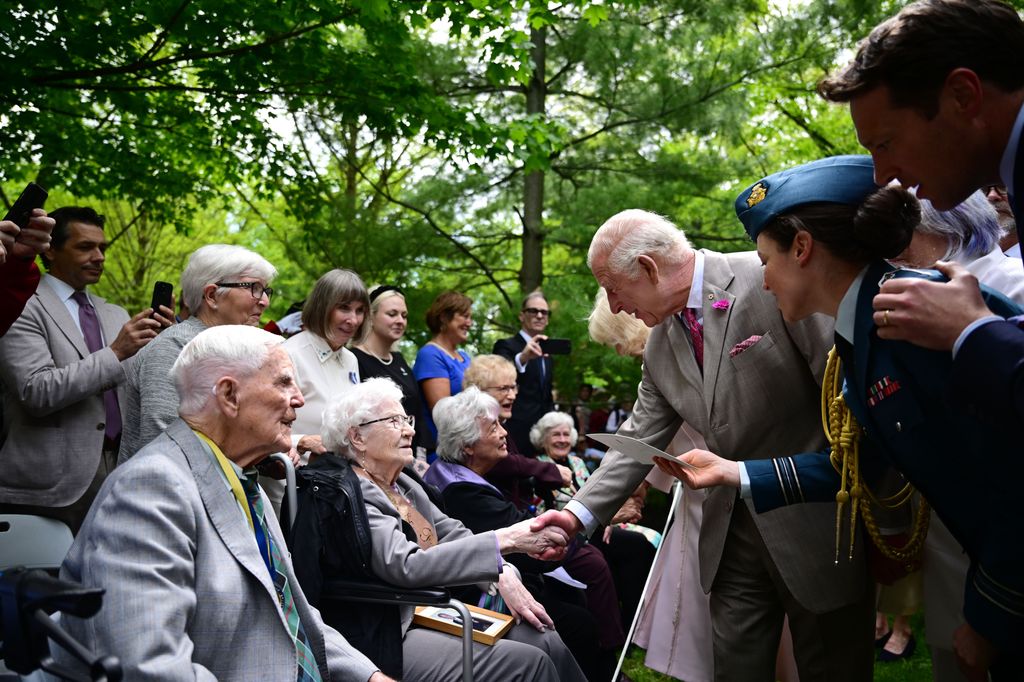 King Charles shaking hands with elderly people for a service
