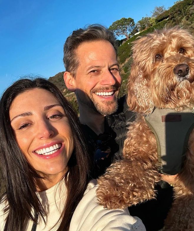 Ioan Gruffudd holding a dog and walking with Bianca Wallace