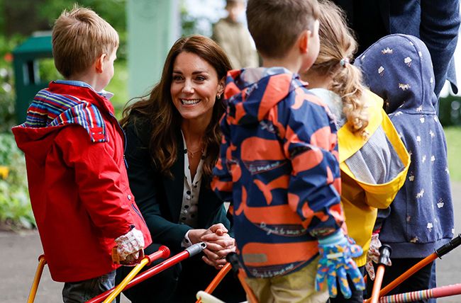 katye middleton beams as she bends down to talk to young school children