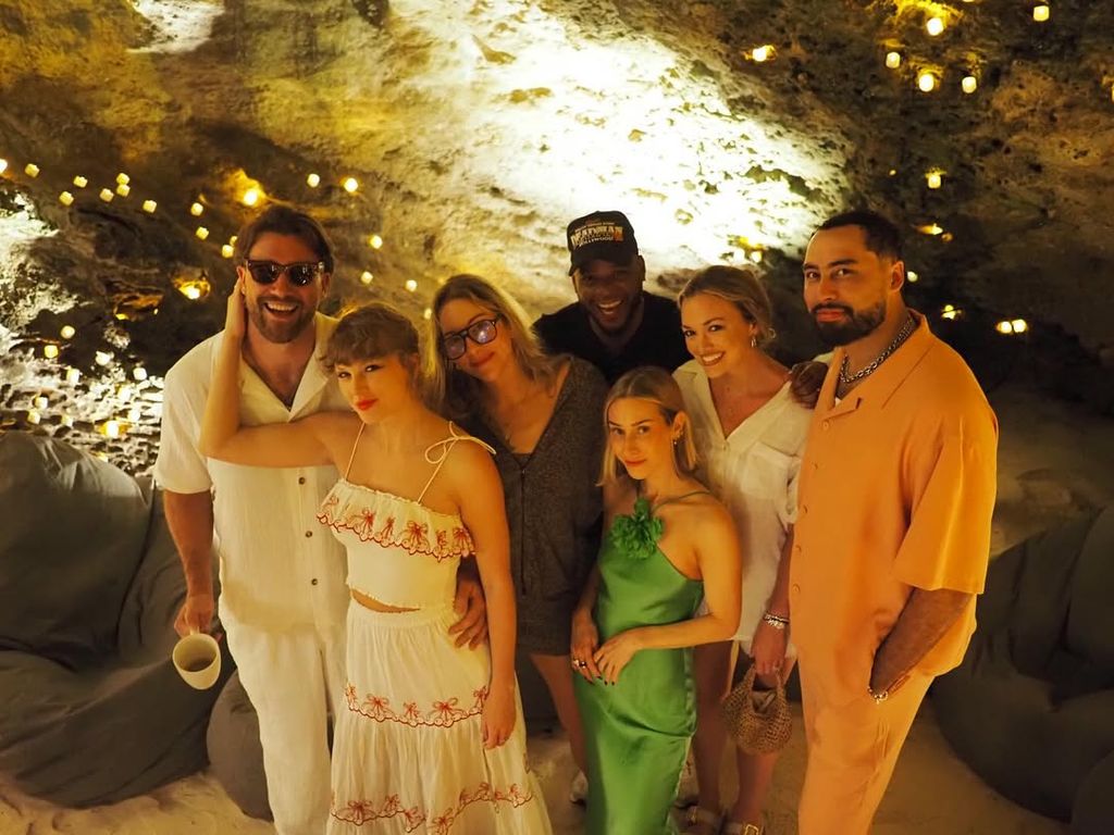 Travis Kelce and Taylor Swift pose in a cave with friends incuding Este Haim