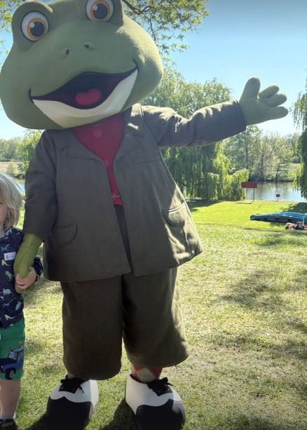 A young boy standing with 'Mr Frog' from The Wind in the Willows