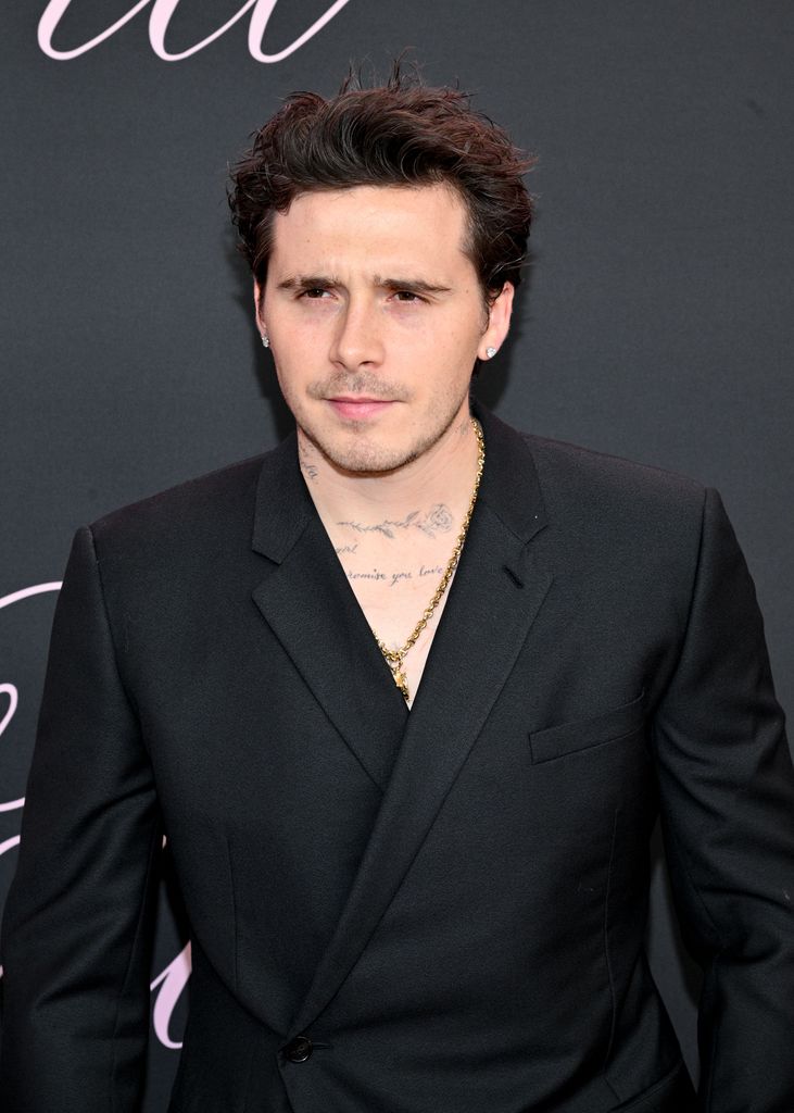 brooklyn beckham posing in black suit