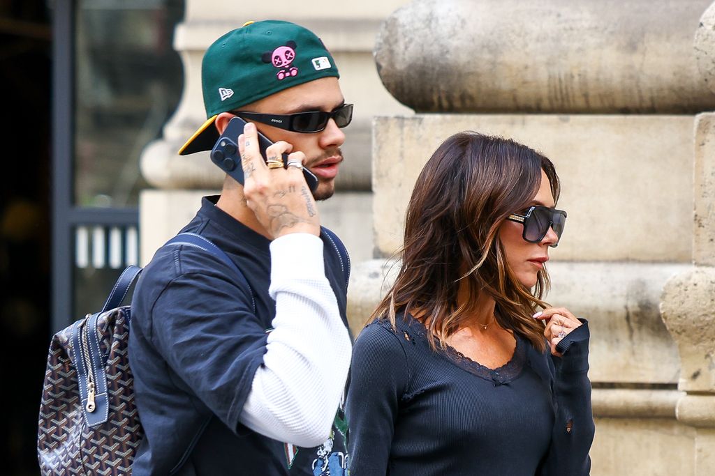 Romeo Beckham and Victoria Beckham walking in Paris with Romeo on the phone