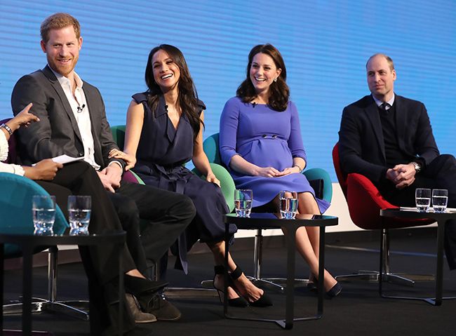 harry meghan kate who is heavily pregnant and william sit side by side in chairs on a stage
