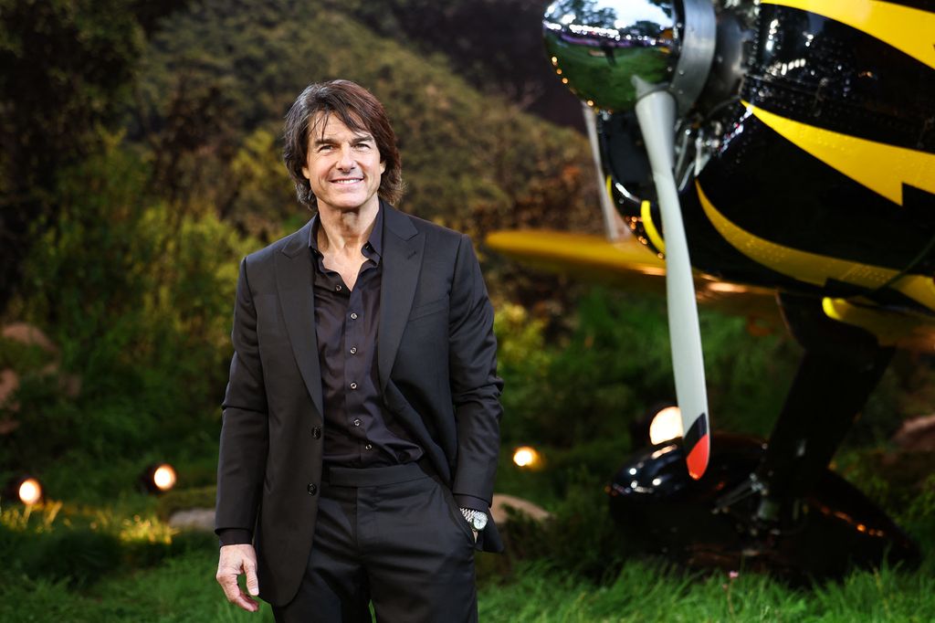 man in black suit next to plane